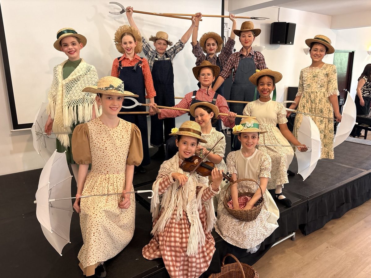 The Junior competition group in farm costumes, one playing a violin